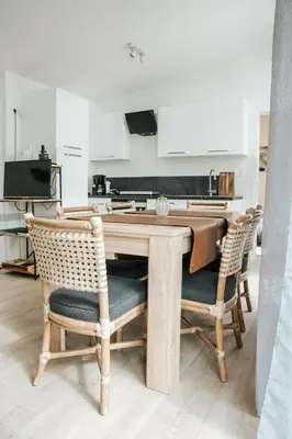 a kitchen with a wooden table and chairs at Trendy chalet aan visvijver in Hamme