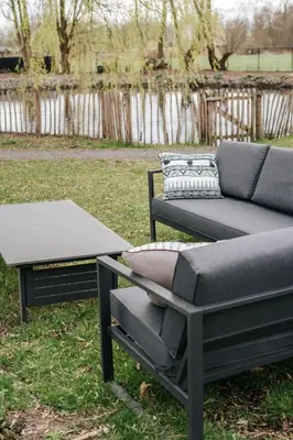 a couch and a coffee table in a yard at Trendy chalet aan visvijver in Hamme