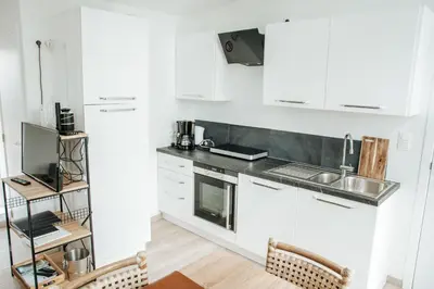 a kitchen with white cabinets and a sink at Trendy chalet aan visvijver in Hamme