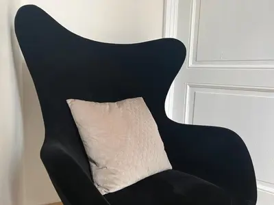 a black chair with a pillow on it at Lily Flower - B&B in Kapelle-op-den-Bos