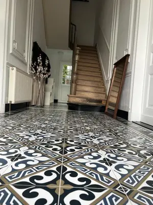 a hallway with a tile floor and a staircase at Lily Flower - B&B in Kapelle-op-den-Bos