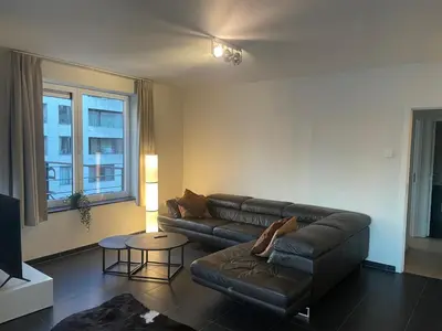 a living room with a couch and a table at Apartment in Heart of Brussel City with Balcony View in Brussels