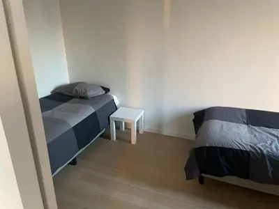 a bedroom with two beds and a small table at Apartment in Heart of Brussel City with Balcony View in Brussels