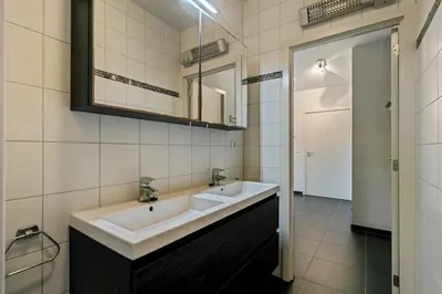 a bathroom with two sinks and a mirror at Apartment in Heart of Brussel City with Balcony View in Brussels