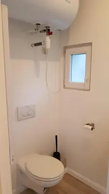 a white bathroom with a toilet and a window at B44 appartment in Brussels
