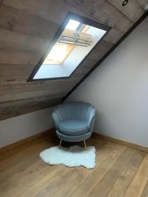 a blue chair in a room with a skylight at Vélo 94 bij Soof in Geel