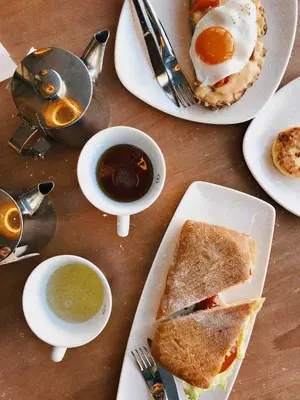 a table with plates of food and a cup of coffee at BB GUESTHOUSE in Wezembeek-Oppem