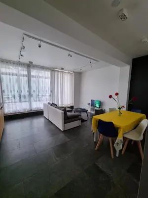 a living room with a yellow table and a couch at BB GUESTHOUSE in Wezembeek-Oppem