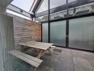 a wooden bench sitting in a room with windows at BB GUESTHOUSE in Wezembeek-Oppem
