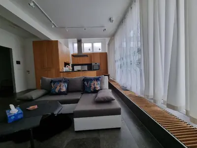 a living room with a couch and a large window at BB GUESTHOUSE in Wezembeek-Oppem