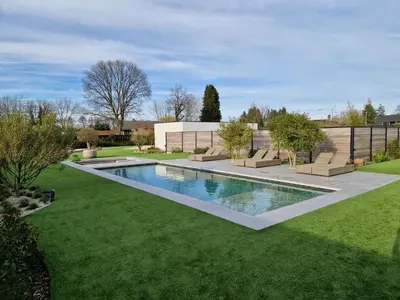 a swimming pool in a yard with green grass at Guesthouse Andor in Balen
