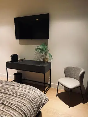 a bedroom with a desk and a chair and a tv at Guesthouse Andor in Balen