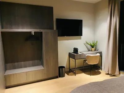 a bedroom with a television and a table and a chair at Guesthouse Andor in Balen