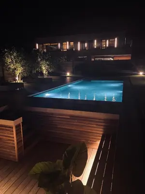 a swimming pool at night with a bench at Guesthouse Andor in Balen