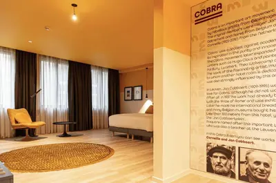 a hotel room with a bed and a wall with a poster at M-Street art lodging - Self check-in in Leuven