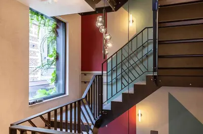 a spiral staircase in a building with a window at M-Street art lodging - Self check-in in Leuven