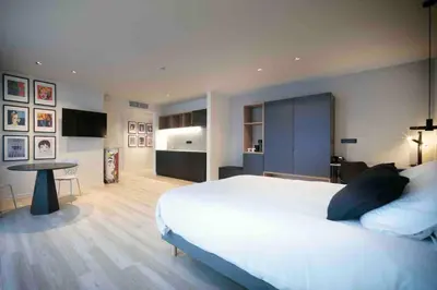 a bedroom with a large white bed and a table at M-Street art lodging - Self check-in in Leuven