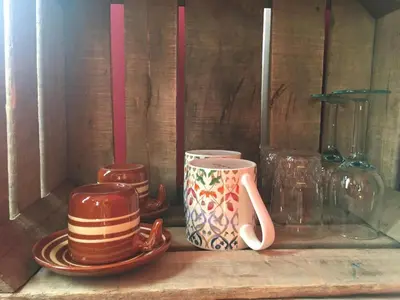a wooden shelf with cups and plates on it at Authentieke privé-kamer bij Karen in Beveren