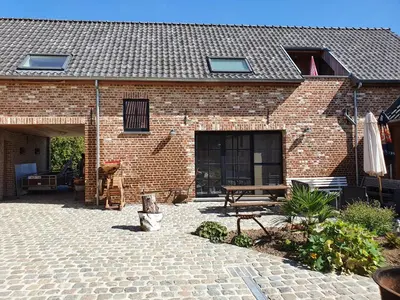 a brick building with a patio and a picnic table at B&B Dekorn in Pepingen