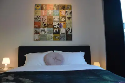 a bed with a pink pillow on top of it at Hippe studio in historisch gebouw in oude centrum in Antwerp