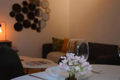 a table with a wine glass and flowers on it at Hippe studio in historisch gebouw in oude centrum in Antwerp