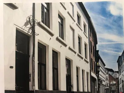 a white building with many windows on a street at Hippe studio in historisch gebouw in oude centrum in Antwerp