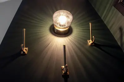 a light hanging from a wall with four lights at Secret Walls in Brussels