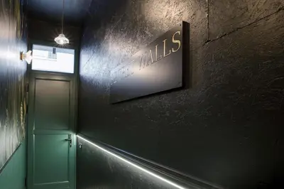 a hallway with a door and a sign on a wall at Secret Walls in Brussels