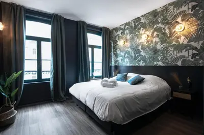 a bedroom with a bed with a tropical wallpaper at Secret Walls in Brussels