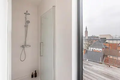 a shower in a bathroom with a view of a city at New apartment with big terrace and great views! in Leuven