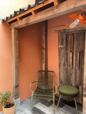 a patio with two chairs and a wooden wall at Bed & Binnekyk in Mechelen
