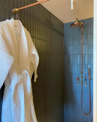 a bathroom with a shower with a white shower curtain at Bed & Binnekyk in Mechelen