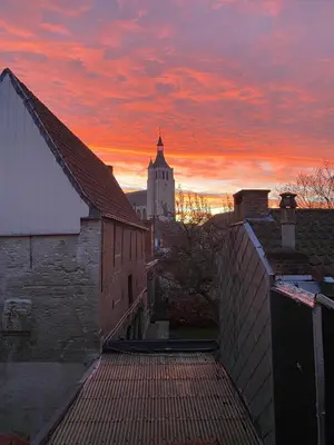a sunset over a city with a clock tower at Bed & Binnekyk in Mechelen