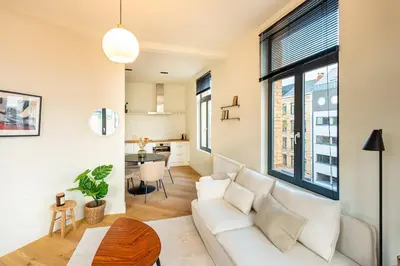 a living room with a white couch and a table at Stijlvol duplex appartement in Antwerp