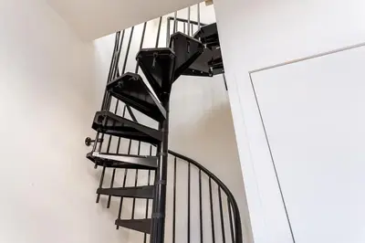 a black spiral staircase in a white room at Stijlvol duplex appartement in Antwerp
