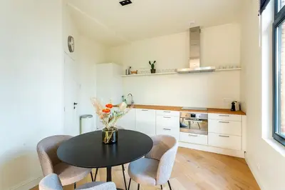 a kitchen with a black table and chairs and a counter at Stijlvol duplex appartement in Antwerp