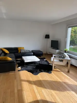 a living room with a black couch and a table at Beautiful 3 bedroom Apartment in Antwerp