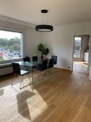 a living room with a glass table and chairs at Beautiful 3 bedroom Apartment in Antwerp