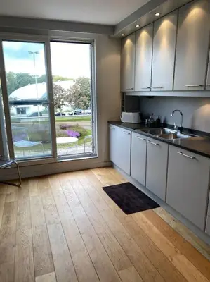 a kitchen with white cabinets and a large window at Beautiful 3 bedroom Apartment in Antwerp