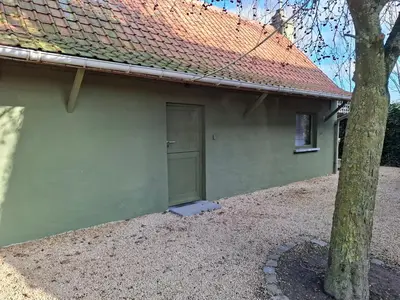 a green house with a door and a tree at Loft aan Puyenbroeck in Wachtebeke