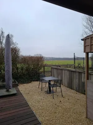 a patio with a table and a bench and a fence at Loft aan Puyenbroeck in Wachtebeke