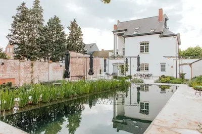 a house with a canal in front of it at Visite in Evergem