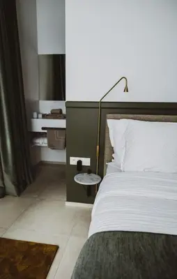 a bedroom with a bed with a lamp and a side table at Visite in Evergem