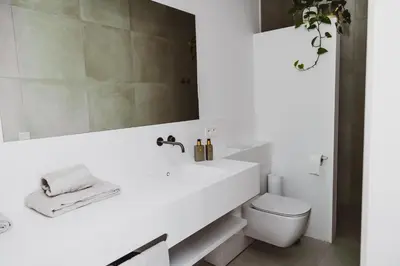 a white bathroom with a sink and a toilet at Visite in Evergem