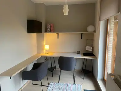 a small room with a desk and chairs in it at La Clé des Champs in Tervuren