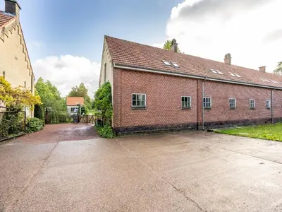 an empty parking lot in front of a brick building at Nice apartment on UNESCO World Heritage Site Wortel-Kolonie in Staakheuvel