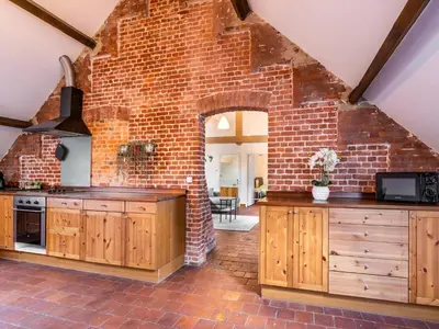an open kitchen with a brick wall and wooden cabinets at Nice apartment on UNESCO World Heritage Site Wortel-Kolonie in Staakheuvel