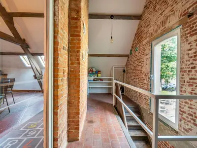 a room with a brick wall and a window at Nice apartment on UNESCO World Heritage Site Wortel-Kolonie in Staakheuvel