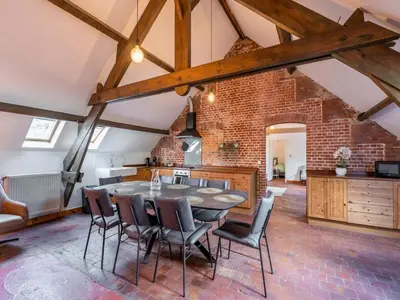 a kitchen with a brick wall and a table and chairs at Nice apartment on UNESCO World Heritage Site Wortel-Kolonie in Staakheuvel