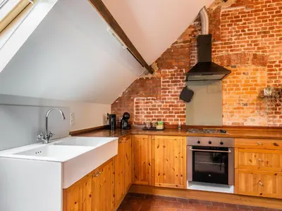 a kitchen with a sink and a brick wall at Nice apartment on UNESCO World Heritage Site Wortel-Kolonie in Staakheuvel